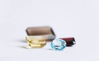 Beyaz bir arka planda çeşitli şekillerde ve boyutlarda değerli taşlar var.