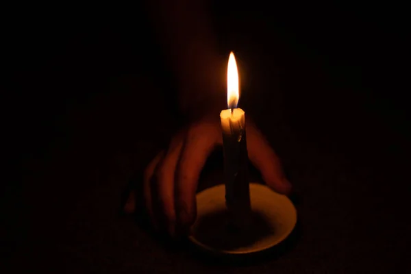 蜡烛的火焰照亮了房间里一个女人的手 — 图库照片