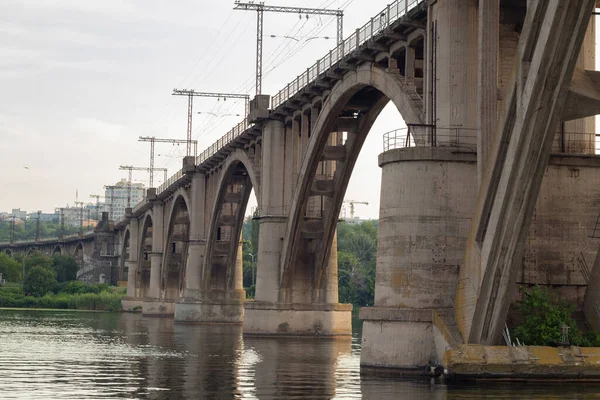 Viejo puente ferroviario sobre el río Dniéper en la ciudad de Dniéper al atardecer —  Fotos de Stock
