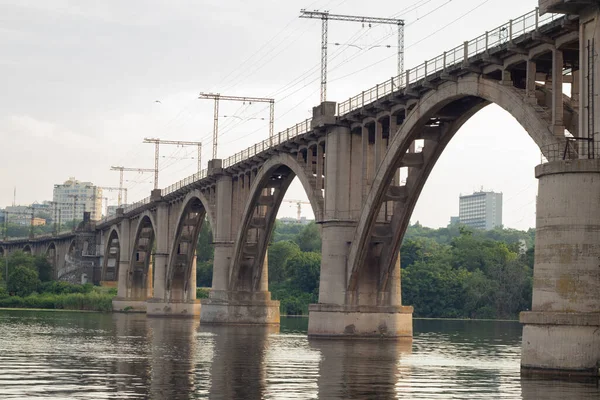 Viejo puente ferroviario sobre el río Dniéper en la ciudad de Dniéper al atardecer —  Fotos de Stock