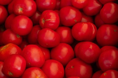 Arka plan olarak çarşıda domatesler var.