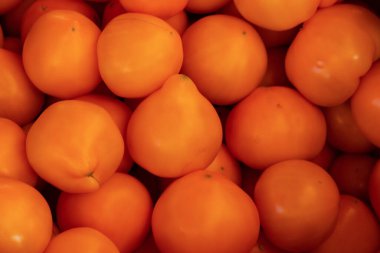 Arka plan olarak çarşıda domatesler var.