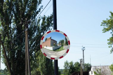 Eğri yol aynası Ukrayna 'da bir yolun yakınındaki bir sütunda asılı.