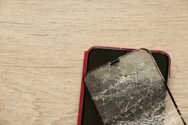 İzole bir arka planda cep telefonu ve kırık camlar, cam değiştirme.