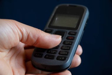 Bir kızın ellerinde düğmeye basarak eski bir cep telefonunu kapat.