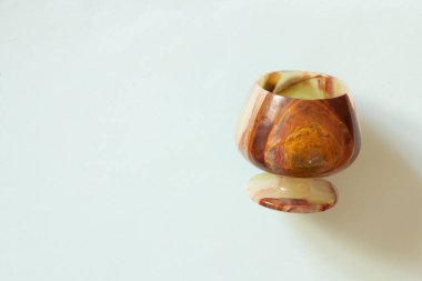 Renkli bir arkaplanda bir bardak oniks taşı. Yakın plan.