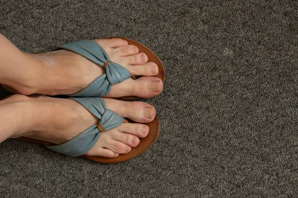Beine Flip Flops Auf Einem Grauen Teppich Der Raumsicht Von — Stockfoto