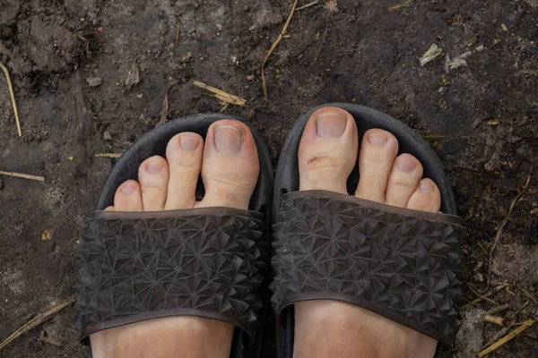 Γυναικεία Πόδια Λαστιχένιες Σαγιονάρες Στέκονται Στο Έδαφος Από Πάνω Προς — Φωτογραφία Αρχείου