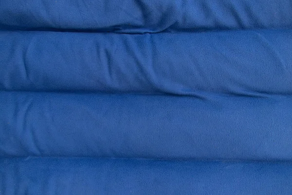 plain dark blue fabric made of artificial materials as wallpaper close up
