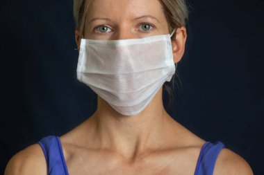 Siyah arka planda tıbbi maskeli kız portresi