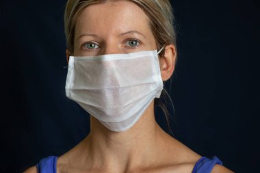Siyah arka planda tıbbi maskeli kız portresi