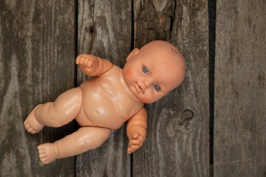 Bebek plastik bebek ahşap bir masada yatıyor. Yakın plan.