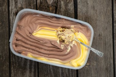 içinde portakallı dondurma ve tatlı kaşığı olan kutu.