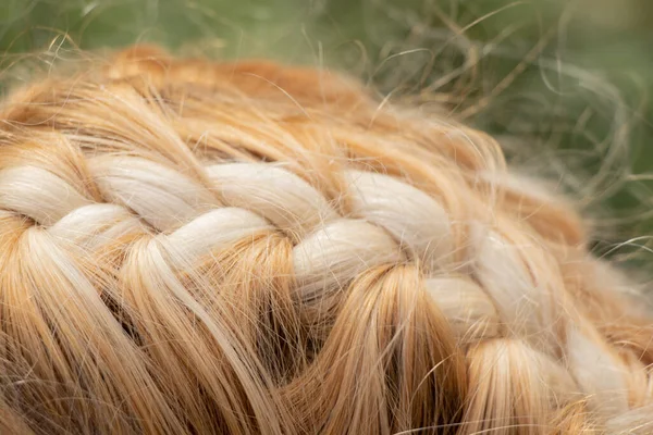 在一个年轻的金发女孩特写的头上缠上辫子 — 图库照片
