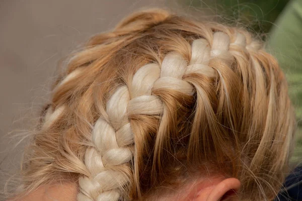 在一个年轻的金发女孩特写的头上缠上辫子 — 图库照片
