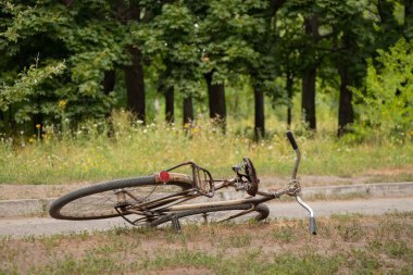 Bisiklet eski yazda yolun kenarında, güneşin altında yol kenarında duruyor.