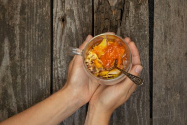 Arka planda dondurmalı meyve ve reçelli bir bardak.