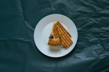 Yeşil arka planda beyaz bir tabakta ev yapımı ballı kek.