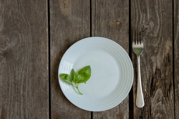 Piatto Vuoto Pulito Forchetta Con Rametto Basilico Poggia Vecchio Tavolo — Foto Stock