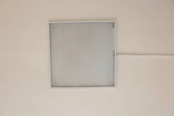 lighting fixture hangs on the ceiling on a light wall view from bottom to top