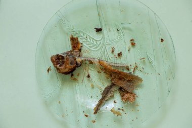 İzole arka planda cam tabakta kızarmış balık iskeleti.