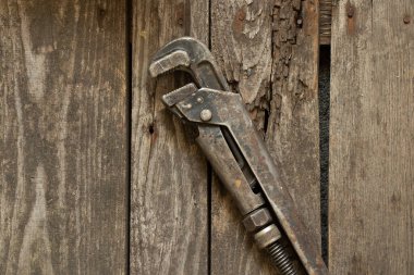 Eski paslı gaz anahtarı ahşap bir masanın üzerinde yatıyor.