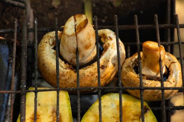 Yazın parkta piknikte ızgarada kabak biberi ve mantar ızgara sebzeler.