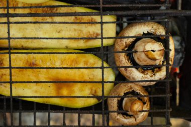 Yazın parkta piknikte ızgarada kabak biberi ve mantar ızgara sebzeler.