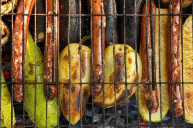Yazın parkta piknikte biberli, mantarlı ve sosisli kızarmış kabak, sebze ve ızgara sosis.