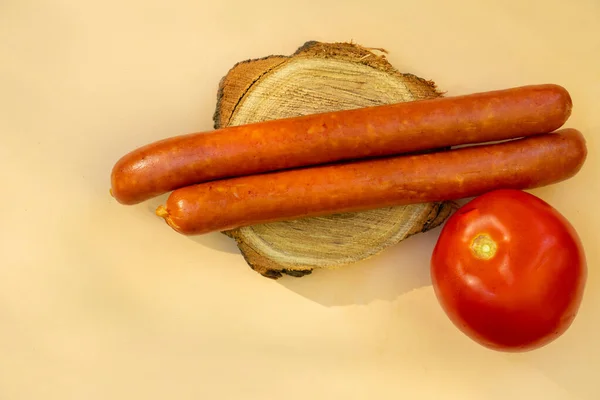 Two Sausages Lie Red Tomato Wooden Board Brown Background Close — Stock Photo, Image