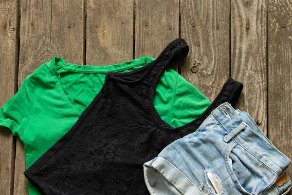 女装短裤和T恤衫绿色和黑色的木制背景特写 — 图库照片