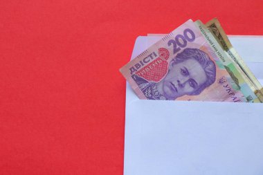 200 'lük banknotta Ukrayna Hryvnia' sı kırmızı arka planda beyaz bir zarfın içinde yatar.