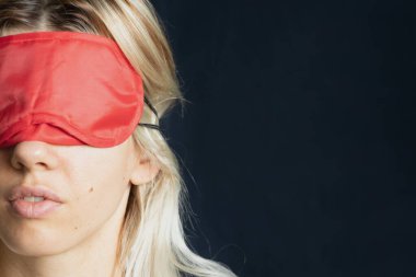 Siyah arka planda uyuduğu için uzun saçlı, tekstil bandajlı bir kız.