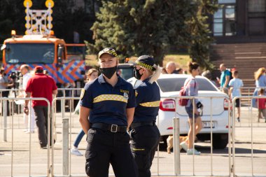 Ukrayna Dnipro - 12 Eylül 2020 - Şehir merkezinde şehir merkezinde şehir meydanında karantina günlerinde maskeli iki polis kız çocuğu, karantina tedbirlerine uymuyorlar, şehir günü