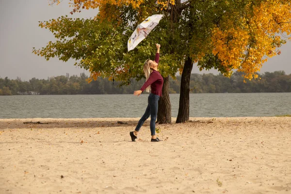 秋のウクライナの強い風の中で公園の噴水を持つ女の子 天気ではなく 秋の強い風 — ストック写真