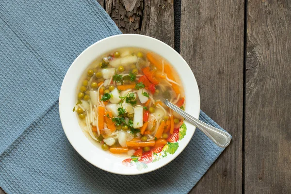 Sopa de legumes caseira em um prato branco na mesa na cozinha, sopa sem carne — Fotografia de Stock