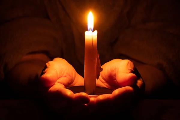 老妇人的手和蜡烛在黑暗中闪耀 蜡烛在黑暗中闪耀 — 图库照片
