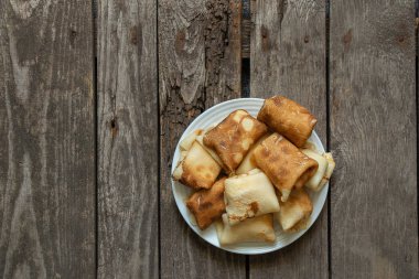 Kahvaltı için bir tabağa sarılmış gözleme mutfakta masanın üstünde, kahvaltıda gözleme var.
