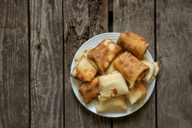 Kahvaltı için bir tabağa sarılmış gözleme mutfakta masanın üstünde, kahvaltıda gözleme var.