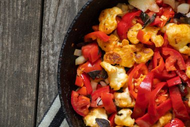 Mutfakta tavada pişmiş domates ve biberli karnabahar var. Et yok, vejetaryen yemeği var.