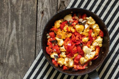 Mutfakta tavada pişmiş domates ve biberli karnabahar var. Et yok, vejetaryen yemeği var.