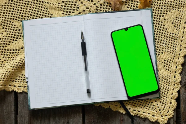 Телефон Зеленым Экраном Блокнот Ручка Сухие Желтые Листья Каштанами Осенью — стоковое фото