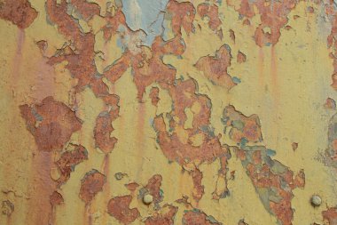Eski metal yüzeyi, arka plan olarak sarı ve yeşil boya ve pas bölgeleri ve pürüzlü ve eski doku.