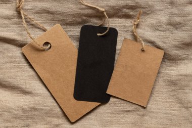 Üç etiket iki kahverengi ve bir siyah bej kumaş üzerinde tasarım için model olarak yatar.