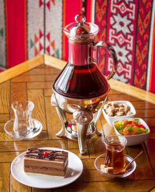 Masada çay, yumru şeker, kurutulmuş meyve ve kek ile Cam çaydanlık