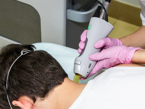 Medical specialist conducts procedure for laser hair removal of the neck