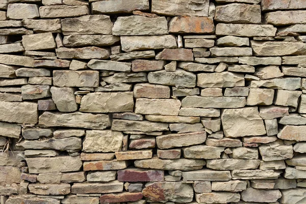 Fragment van een muur van een natuurlijke berg steen met een kleine impregnatie van droge takken — Stockfoto