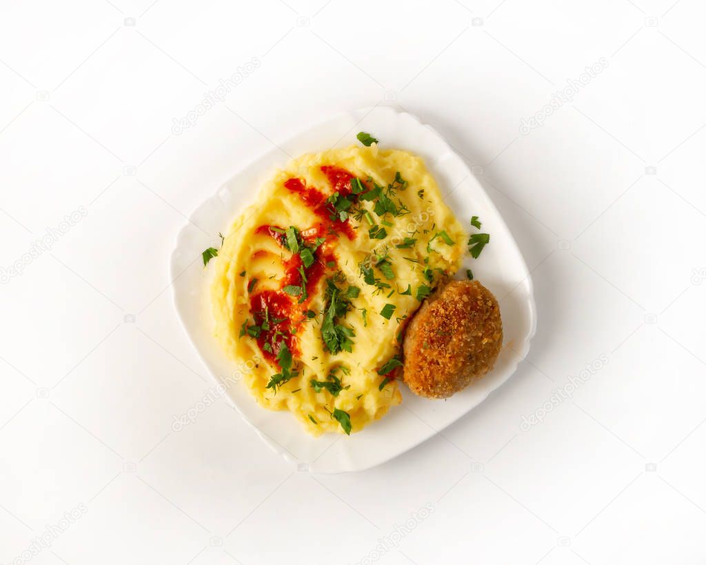 Chicken cutlet with mashed potatoes with red sauce and chopped herbs on white background top view