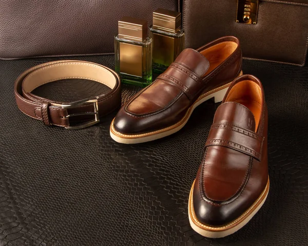 Conjunto de sapatos masculinos castanhos, cinto de cintura e duas garrafas de perfume masculino no fundo de pastas masculinas marrons — Fotografia de Stock
