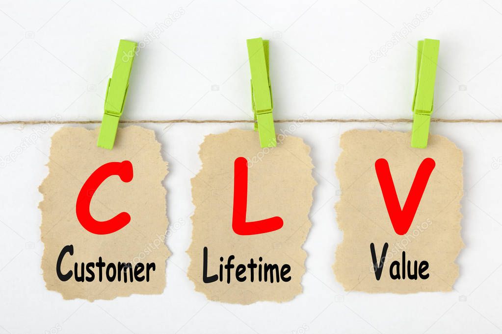 Customer Lifetime Value- CLV writen on old torn paper with clip hanging. Acronym business concept.